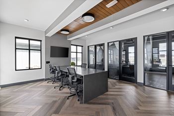 A conference room with a long table and chairs and a tv